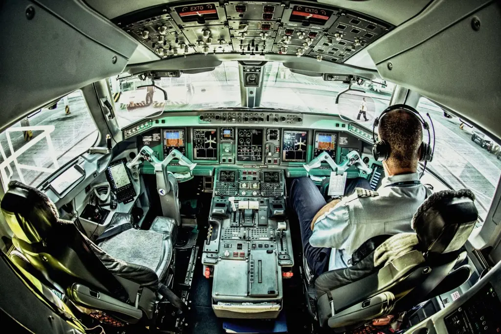 Two pilots in an airliner flight deck above the clouds
